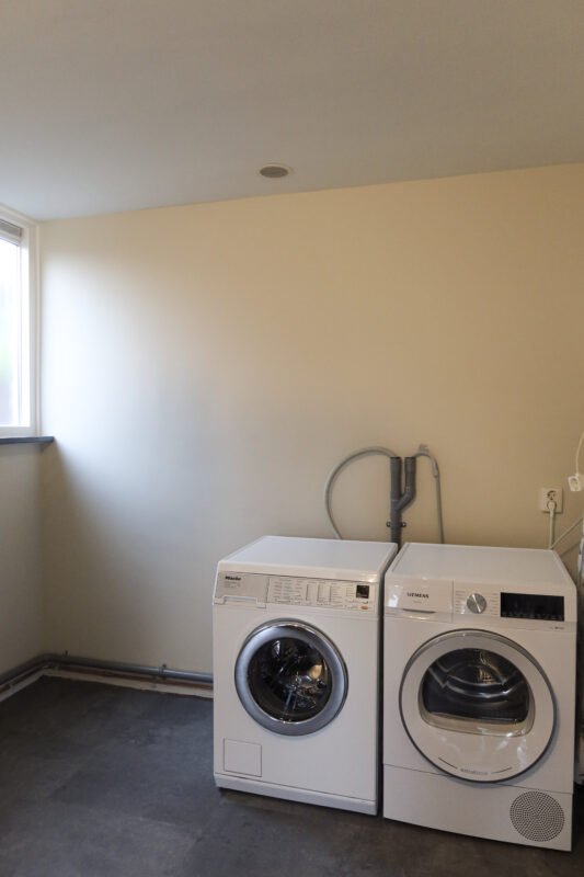 Wasmachine en droger op de grond en niet waterpas